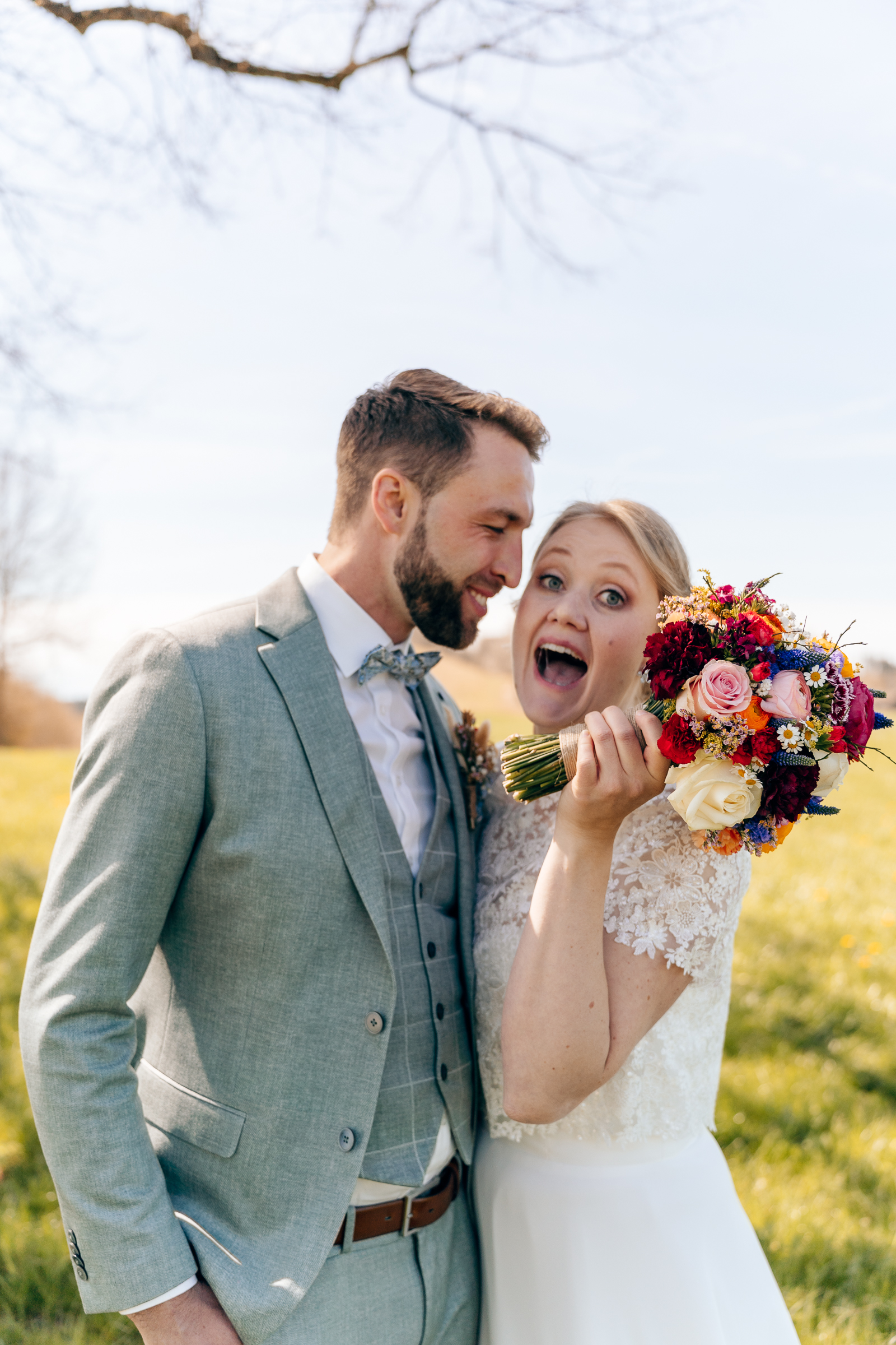 Verliebtes Hochzeitspaar versteckt sich hinter Blumenstrauß - Hochzeitsfotografie Bodensee
